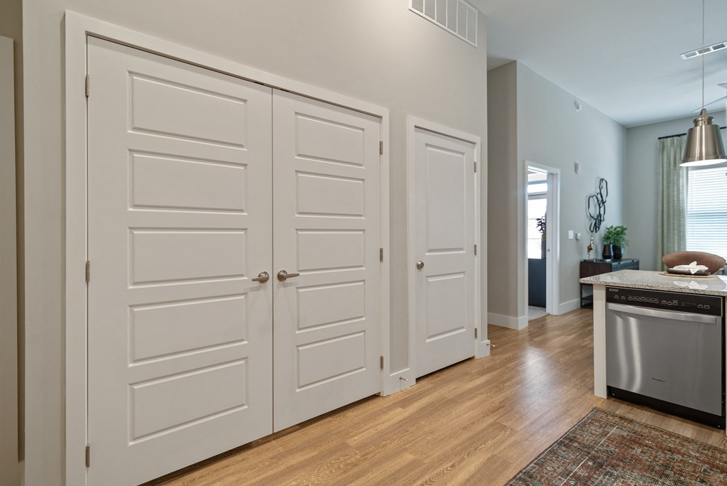 a kitchen with white doors and a counter top and a sink