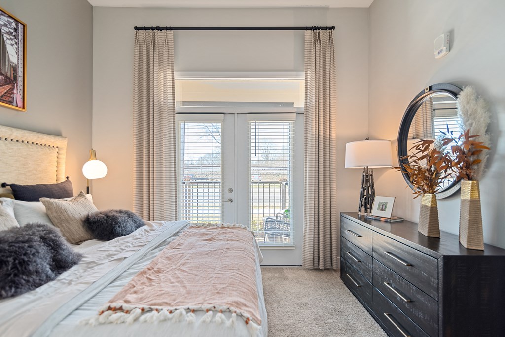 a bedroom with a bed and a dresser and a window