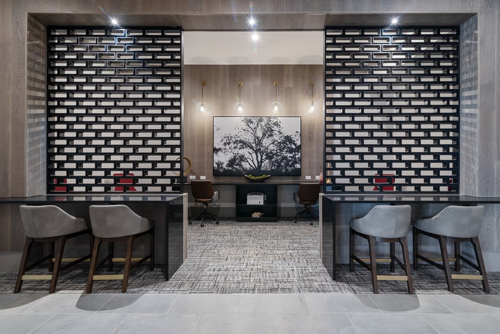 a lobby with a bar and chairs and a brick wall