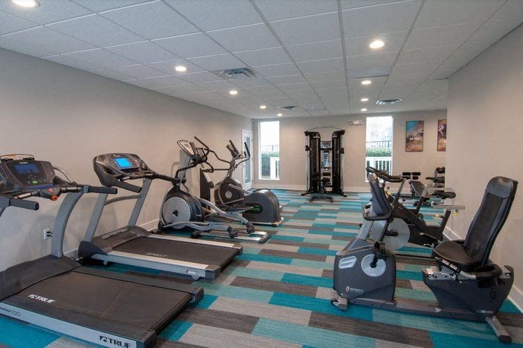 a gym with cardio machines and weights on the floor