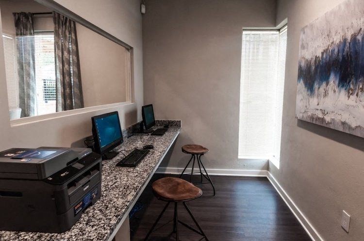 an office with a desk with two computers on it