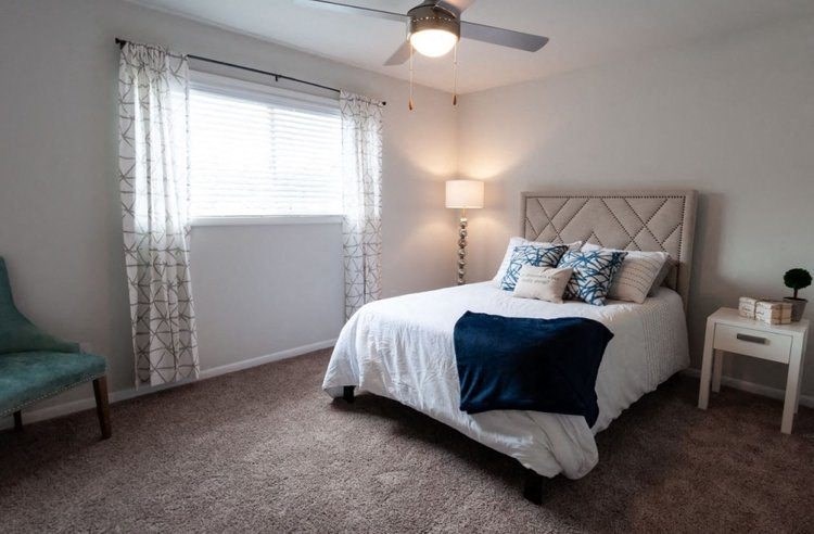 a bedroom with a bed and a ceiling fan