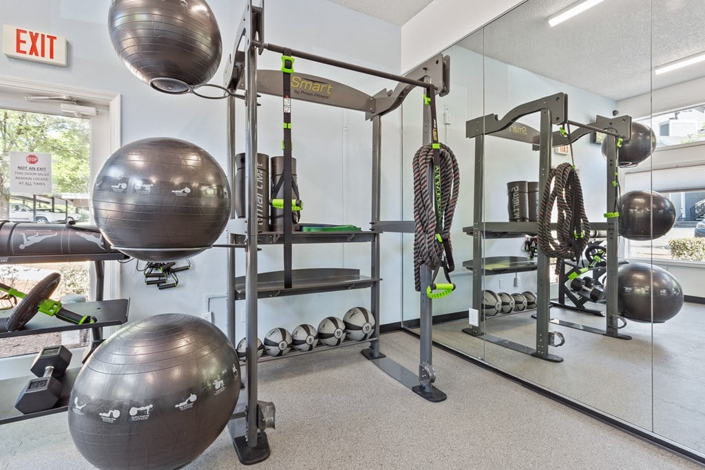A gym with a variety of equipment including a squat rack, a bench, and a mirror. at Cedar Crest, Oregon