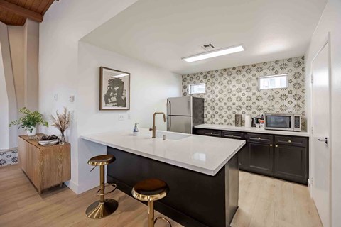 A kitchen with a white countertop and black cabinets.