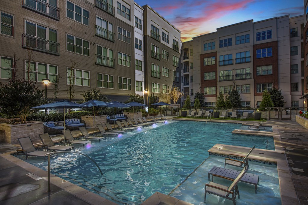 Atlanta Apartments - Arabelle Perimeter - resort heated swimming pool with chairs and umbrellas at dusk