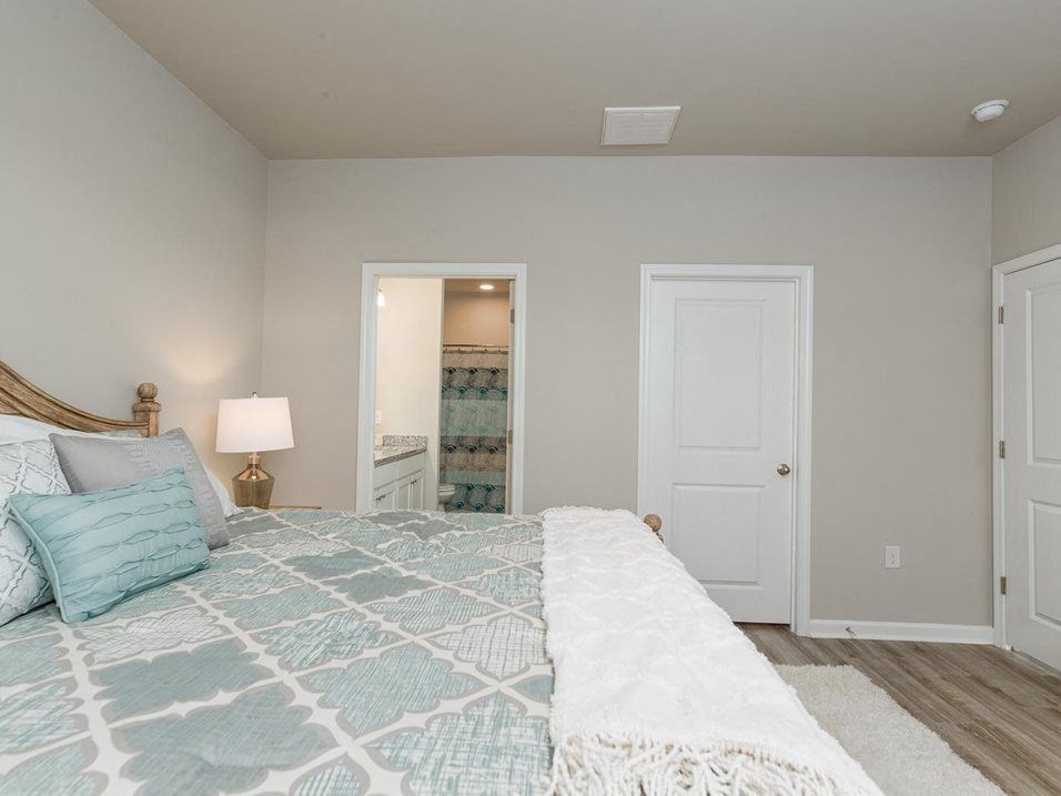 a bedroom with a bed and a door to a bathroom