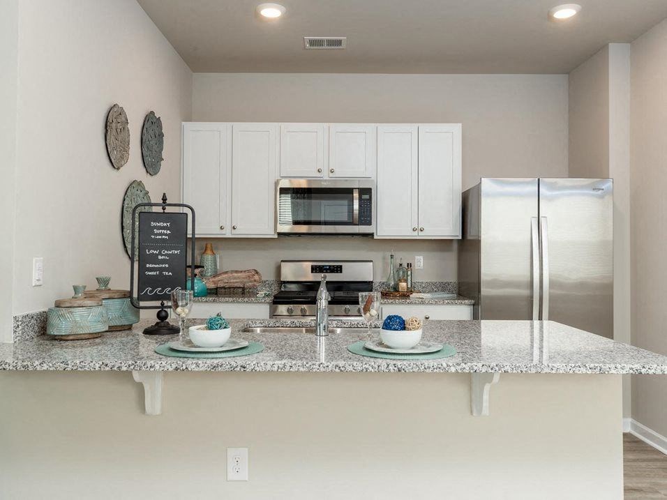 Homes For Rent In Myrtle Beach SC - The Palmer At Carolina Forest - Kitchen with Granite Countertops, Stainless Steel Appliances, and Crisp White Cabinets with Round Nickel Hardware