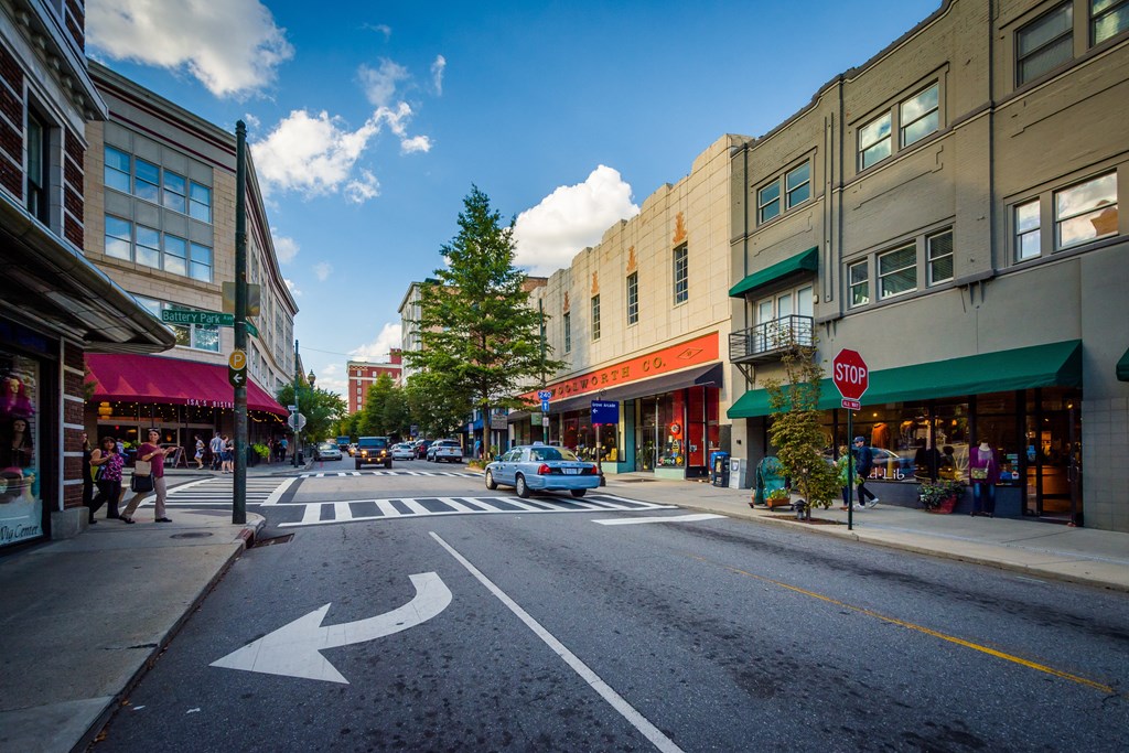 a city street with a blue car driving down it