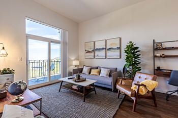 a living room with a couch and a chair and a balcony
