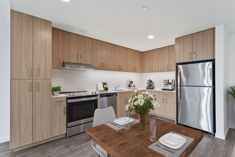 a kitchen with wooden cabinets and stainless steel appliances and a wooden table
