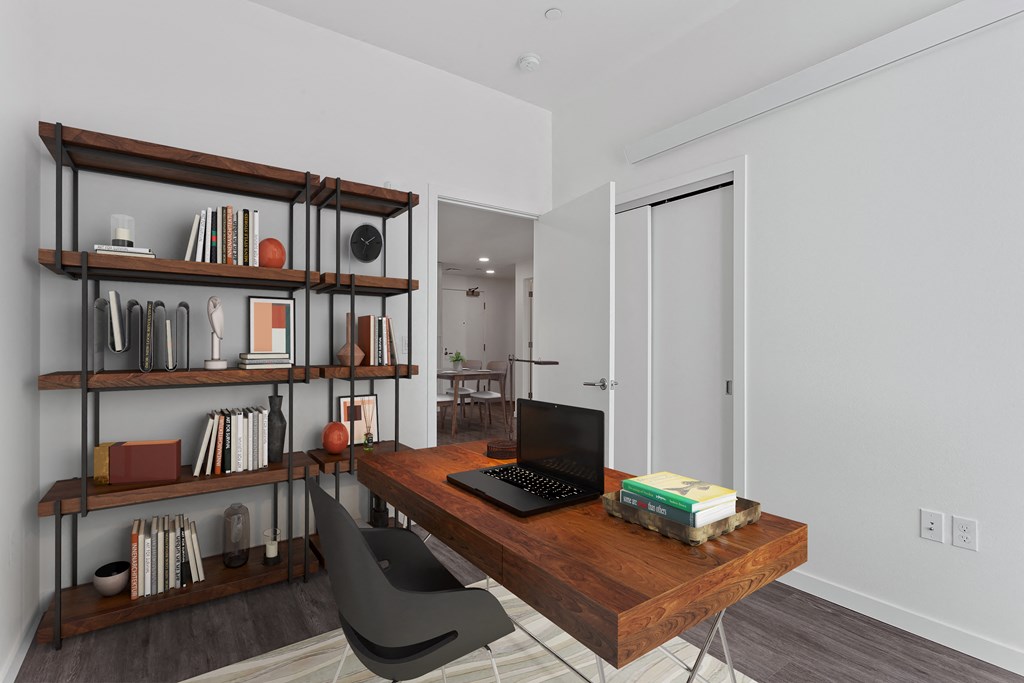 a home office with a wooden desk and a bookshelf