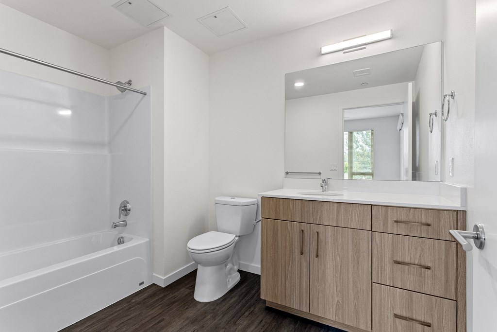a bathroom with white walls and a wooden floor