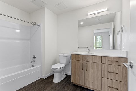 a bathroom with white walls and a wooden floor