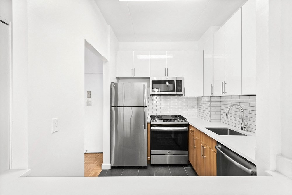 a kitchen with stainless steel appliances and white cabinets