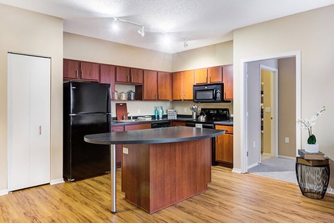 a kitchen with a island and a black refrigerator