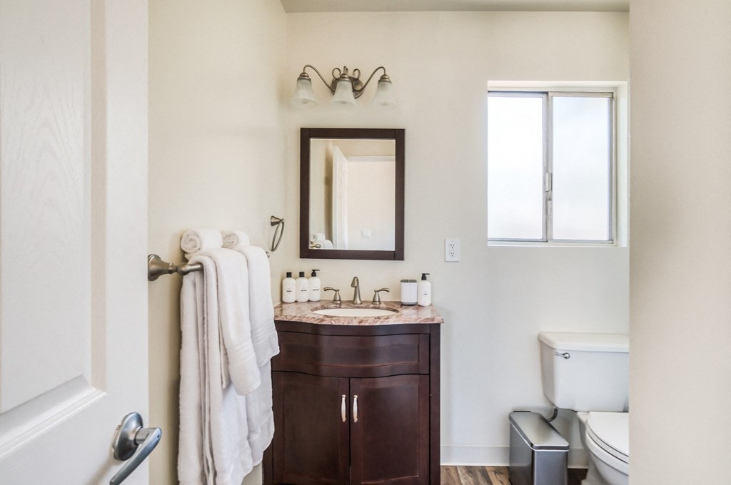 a bathroom with a toilet sink and mirror