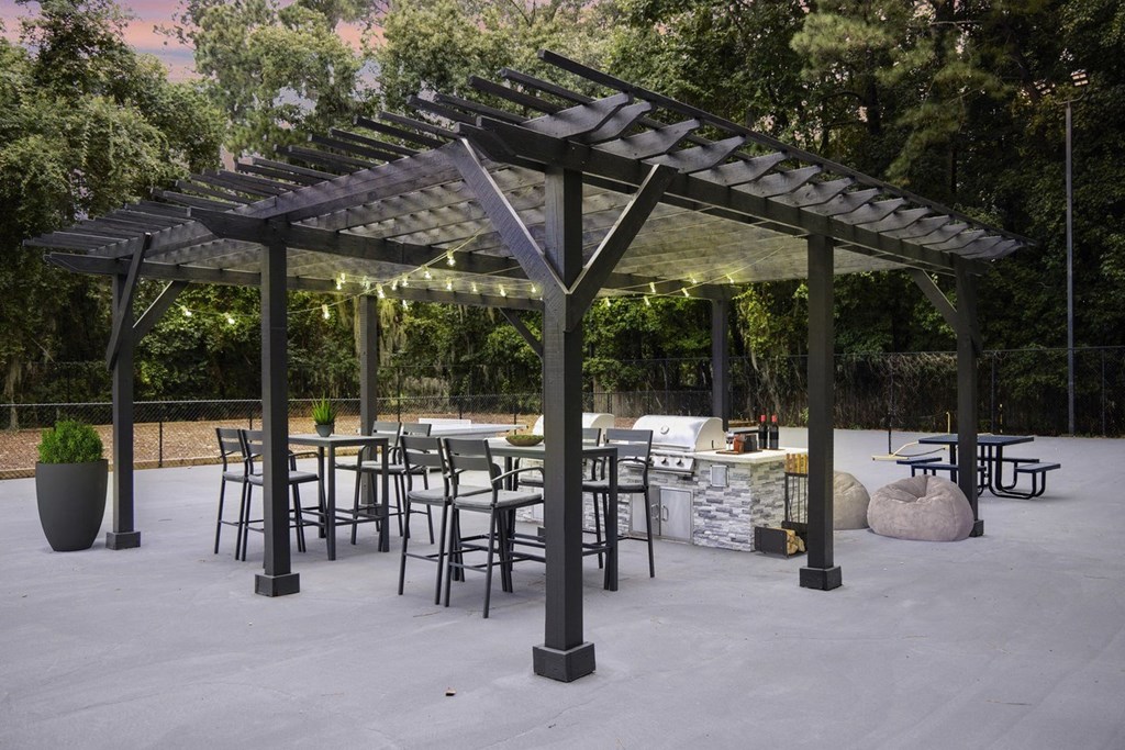Greentree Apartments in Savannah, GA photo of a patio with tables and chairs and a pergola