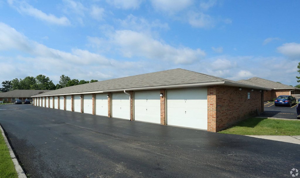 a building with white garage doors and a parking lot