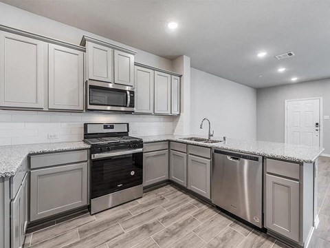 a kitchen with stainless steel appliances and white cabinets