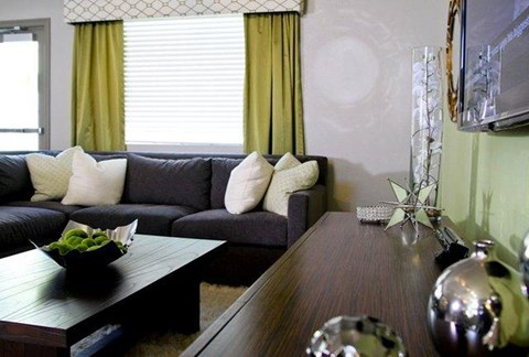 A living room with a grey couch and a wooden coffee table.
