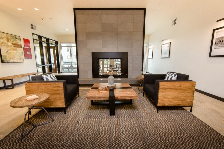 a living room with couches a table and a fireplace