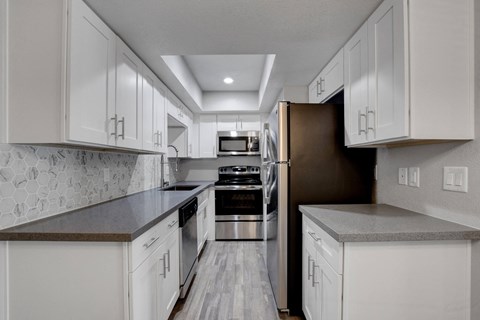 A kitchen with white cabinets and a black stove top oven.