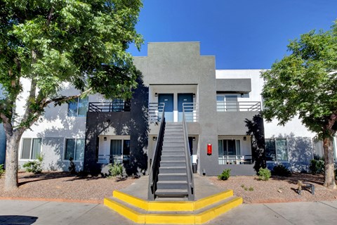 A modern house with a grey facade and a staircase leading to the entrance.