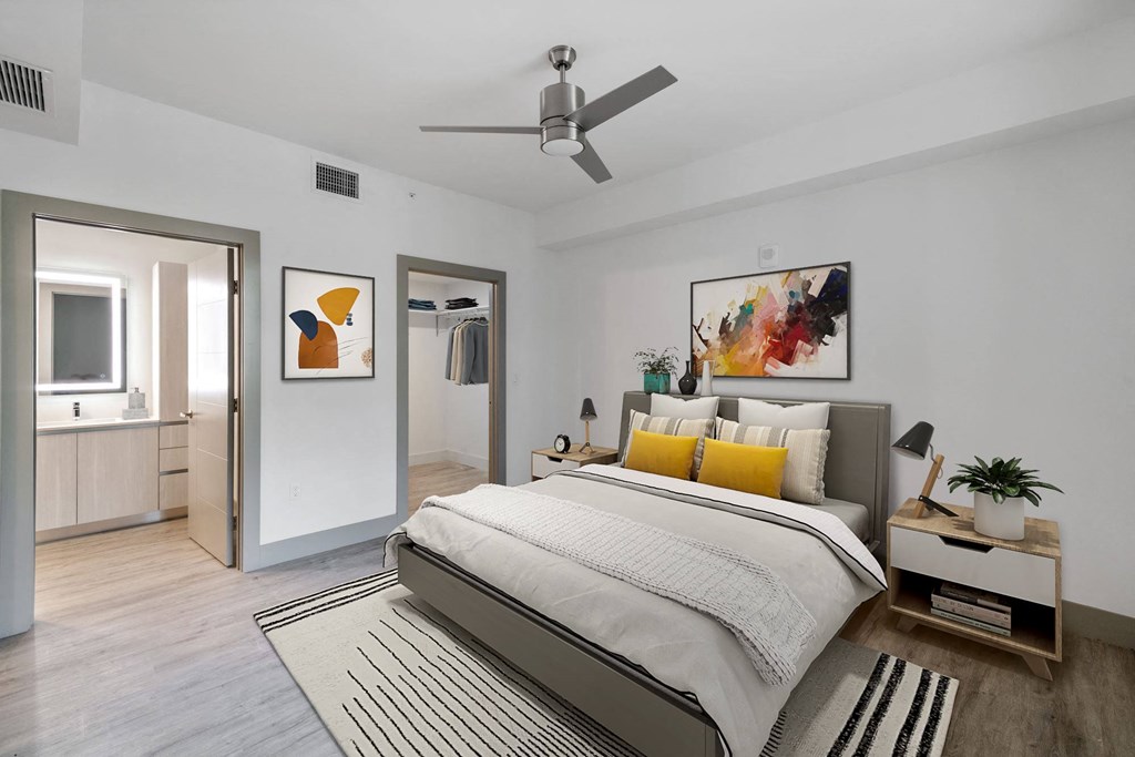 Pet-Friendly Apartments in Boca Raton, FL – CERU - a bedroom with a bed, ceiling fan, and hardwood floors