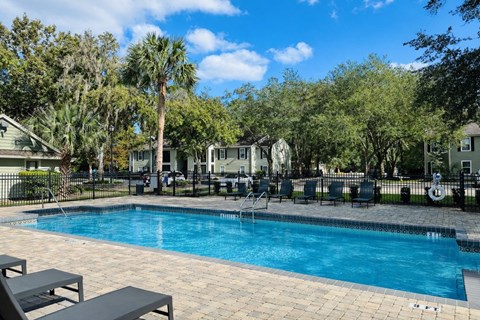 Community swimming pool with lounge seating at Chelsea Apartments in Gainesville FL