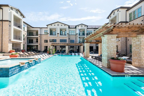 A large swimming pool in front of apartment buildings.