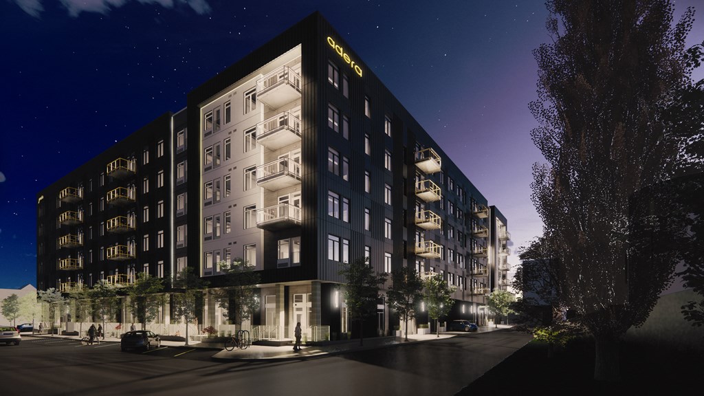 Luxury Apartments for Rent in Vancouver, WA - Adera - Property Exterior at Night with Black Walls, Private Balconies, Parking, Street Lights, and Beautiful Landscaping