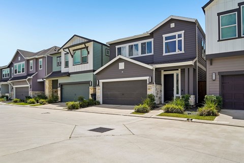 A row of houses with garages in front.