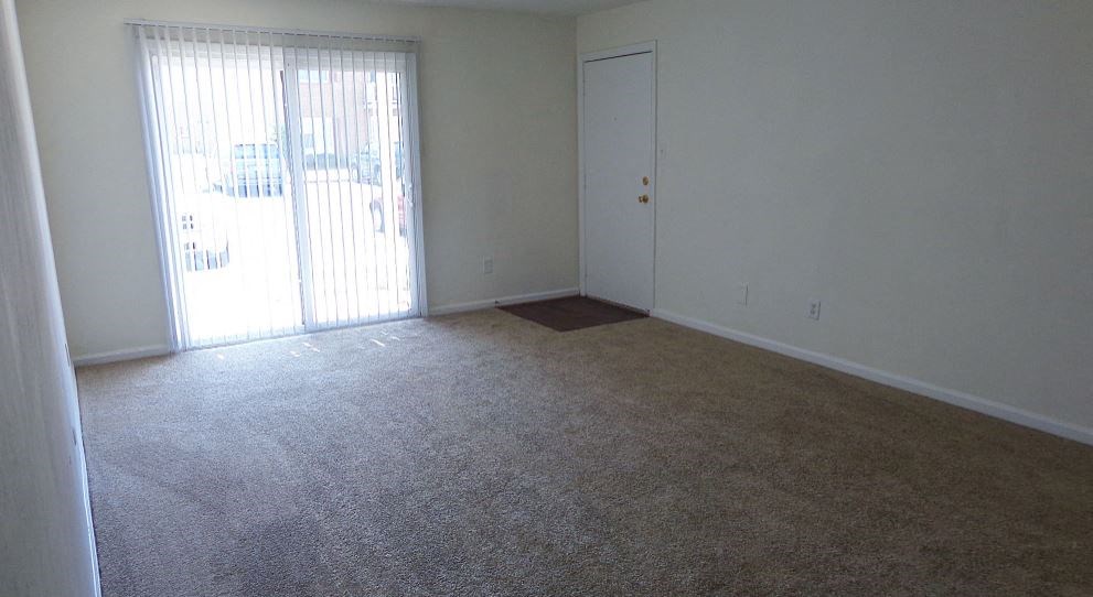 an empty living room with a sliding glass door