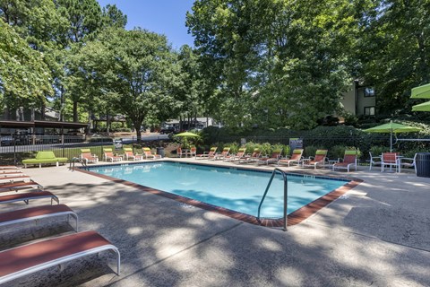 a resort style pool with chairs and trees