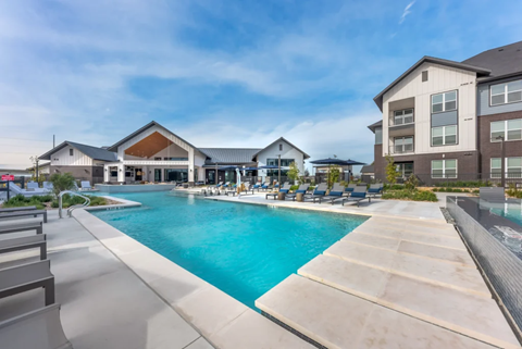 A large swimming pool in front of a resort-style building.