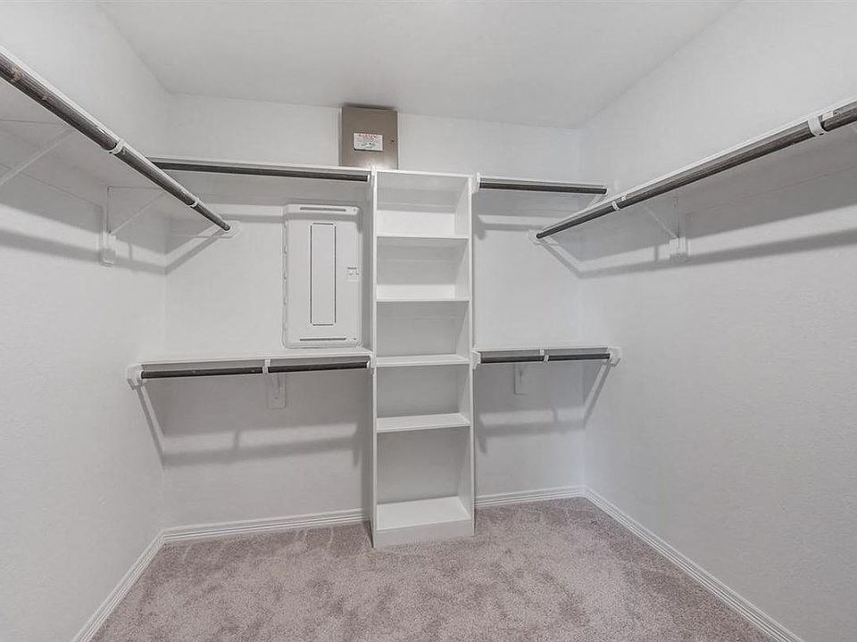 a white closet with shelves and a dryer in it