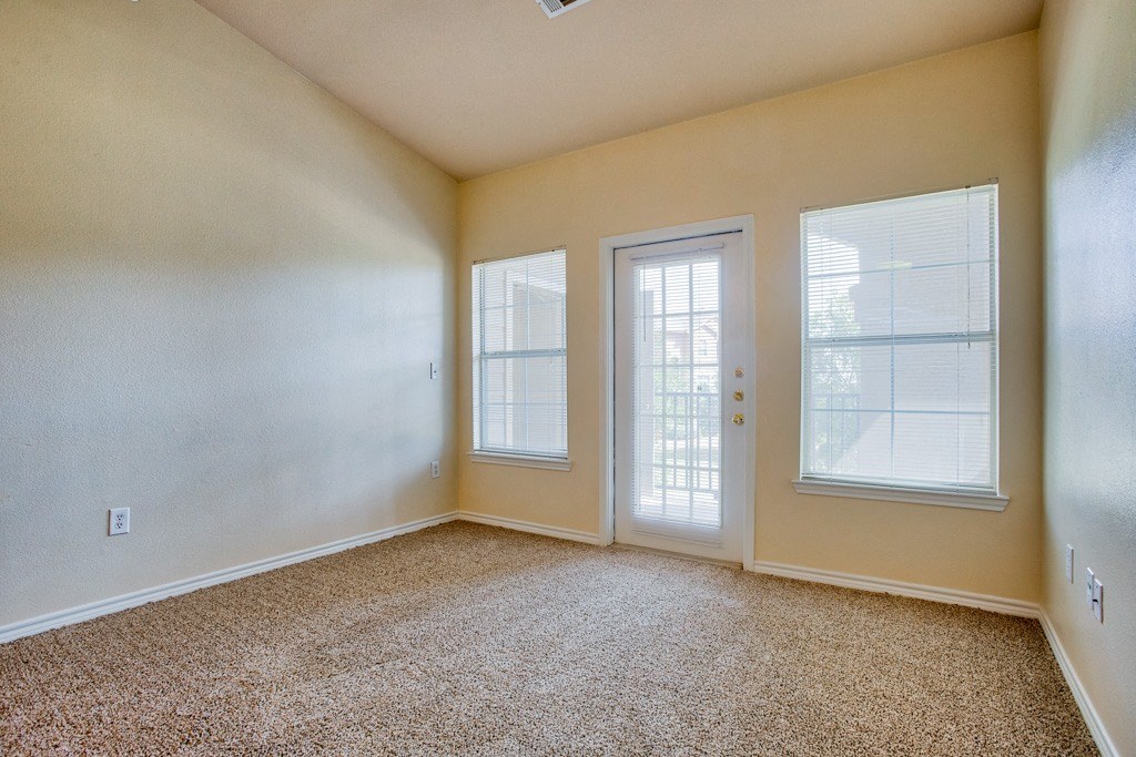 Living room with carpet and glass door and windows with blinds