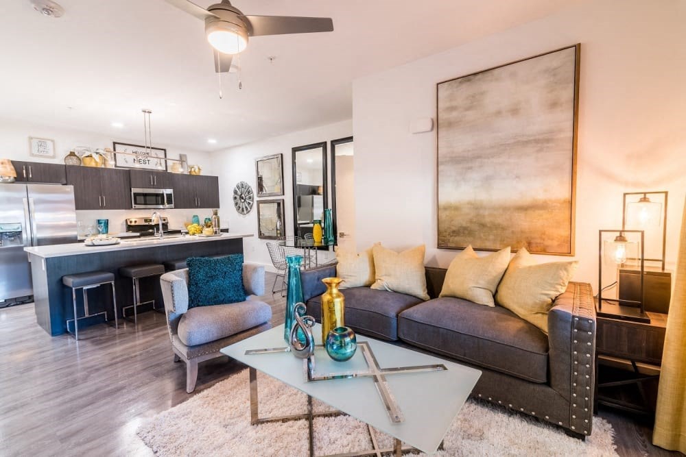 A living room with a coffee table and couch and chairs and island and microwave and stove and oven