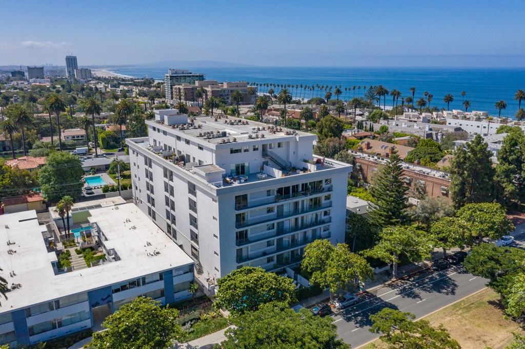 an aerial view of a large white building with a view of the ocean in the background