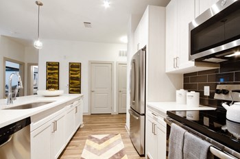 Apartments Garland - Spacious Kitchen with White Counters, White Cabinets, and Stainless Steel Appliances - Photo Gallery 2