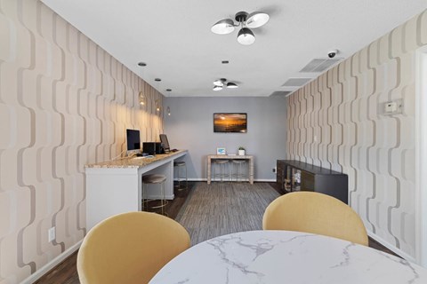 A modern dining room with a white marble table and yellow chairs.