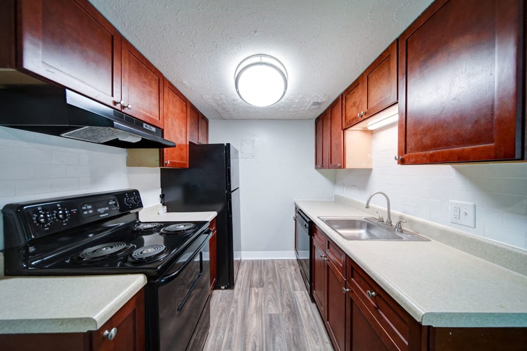 a kitchen with dark wood cabinets and white countertops