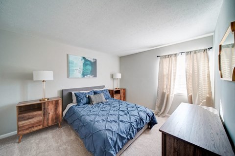 a bedroom with a bed and a window with curtains