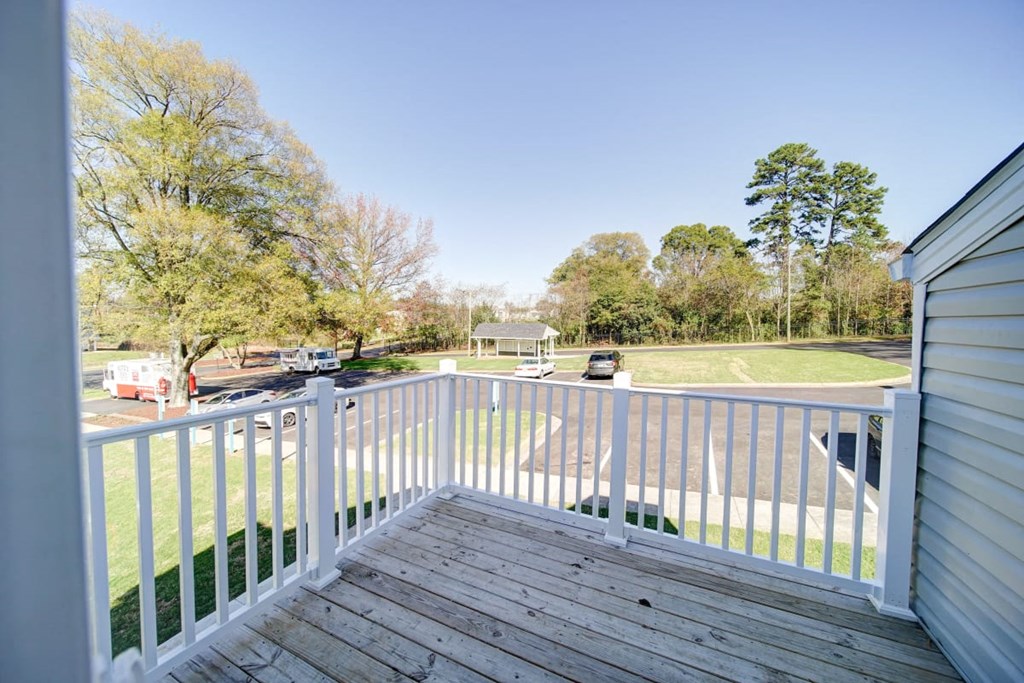 a view from the deck of a home with a baseball field in the background