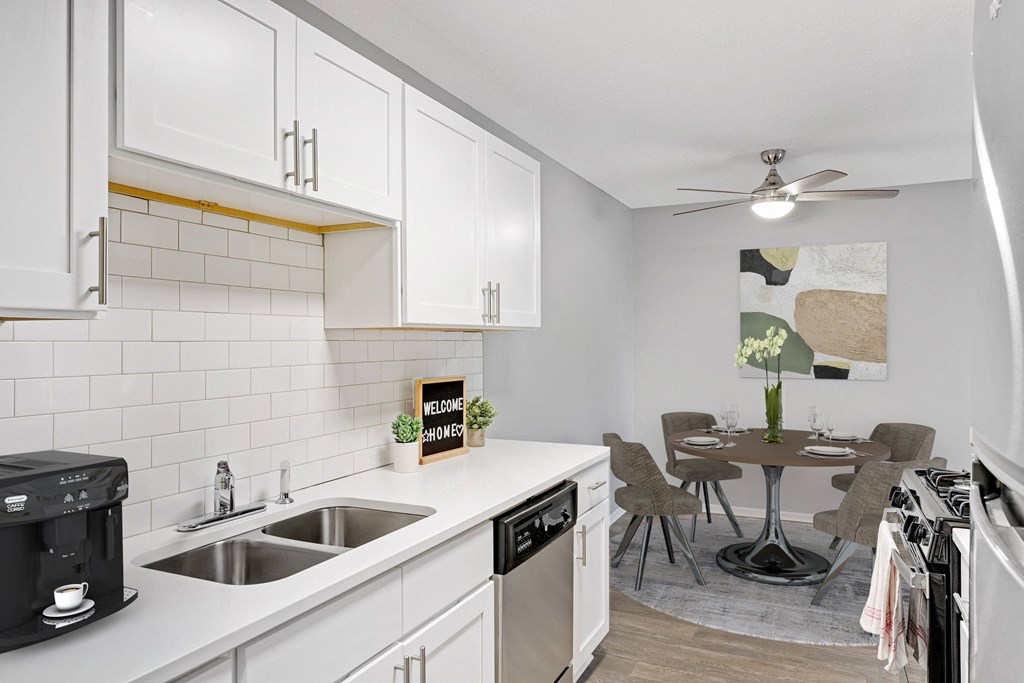 Stratford Wood Apartments and Townhomes in Minnetonka, MN Photo of  an open kitchen and dining area with a table and chairs and a sink