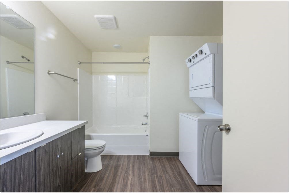 a bathroom with a toilet sink and a washer and dryer