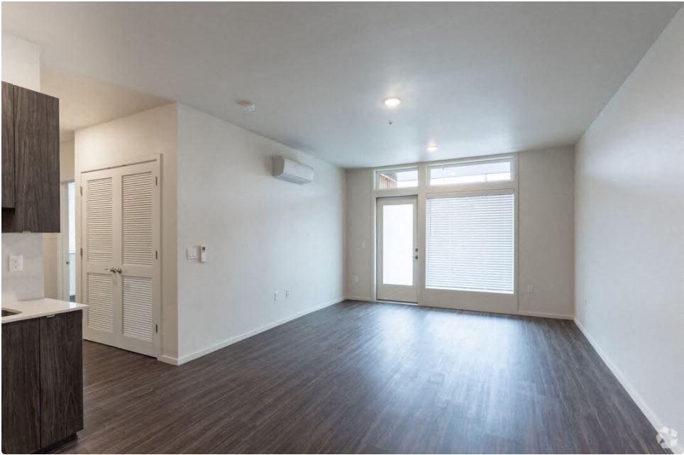 an empty living room with white walls and wood floors