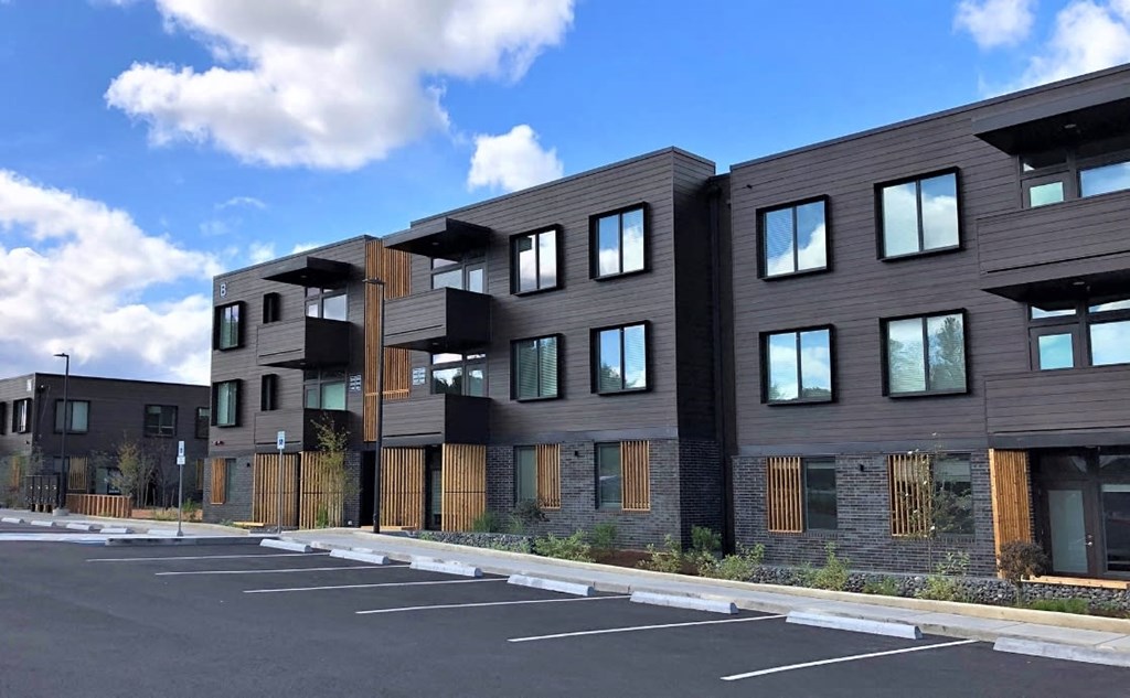 a row of new apartment buildings in a parking lot