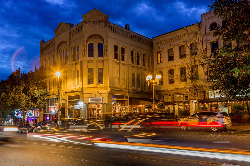 a city street at night with cars and buildings