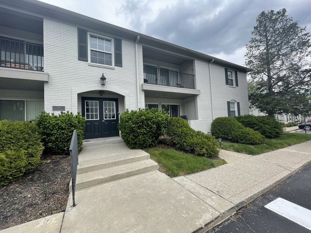 a white house with a black door and white siding